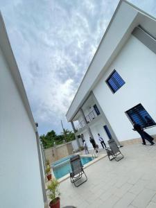 Zwei Personen führen ihre Hunde in einem Haus mit Pool spazieren. in der Unterkunft Charnel hosting in Kribi