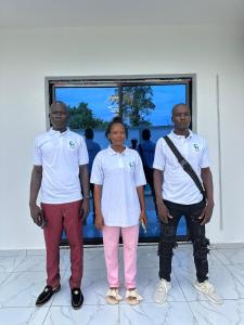 eine Gruppe von drei Personen, die nebeneinander stehen in der Unterkunft Charnel hosting in Kribi