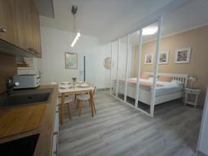 a kitchen and a bedroom with a bed and a table at Apartmán Kathryn in Dubá