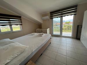 a bedroom with a large bed and two windows at mavikösk apartement in Dalyan