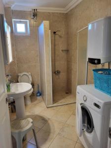 a bathroom with a washing machine and a sink at mavikösk apartement in Dalyan