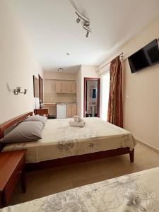 a bedroom with a large bed and a television at Marie Claire Studios in Olympic Beach