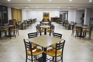 an empty restaurant with tables and chairs in a room at Bansari Greens Resort in Sādra