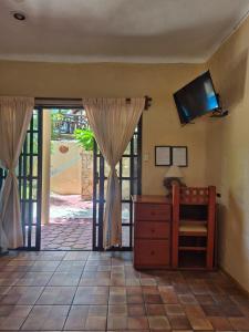 ein Zimmer mit einer Kommode und einem Fernseher an der Wand in der Unterkunft Hotel Casa el Moro in Puerto Morelos