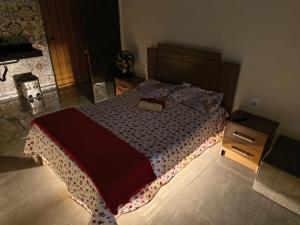 a bedroom with a large bed and a night stand at Quarto Privativo in Caparaó Velho