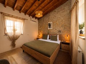 a bedroom with a bed and a brick wall at Four Stories Lefkara in Pano Lefkara
