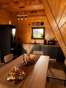 eine Küche mit einem Holztisch, auf dem ein Teller mit Essen steht in der Unterkunft Ocna Frame - A Frame cu Jacuzzi si Terasa in Ocna-Mureşului