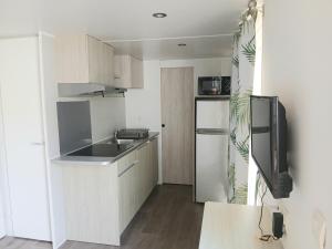 a small kitchen with a sink and a refrigerator at Camping de Bourges in Bourges