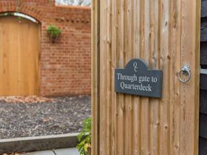 a sign on the side of a wooden fence at Quarter Cottage in Biddenden