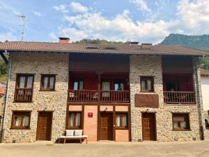 a large brick building with a balcony on it at Monte Subiedes, Apartamentos Valle de Camaleño in Camaleño