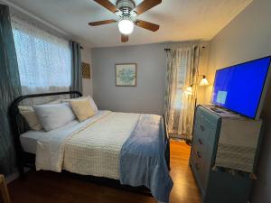 a bedroom with a bed and a flat screen tv at Jefferson Carriage House Hideaway in Huntington