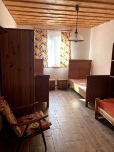 a bedroom with a bed and a chair and a window at Cottage by the Ponds in Krasňany