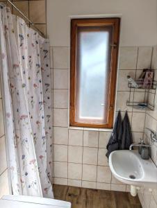 a bathroom with a shower curtain and a sink at Cottage by the Ponds in Krasňany