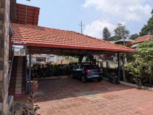 a car parked in a garage with an orange roof at Coorg Relax Home in Madikeri