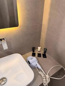 a bathroom with a hair dryer on a counter next to a sink at Vila Llaman Luxury Rooms in Himare