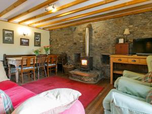 a living room with a fireplace and a table with a couch at The Smiddy - S4278 in Lochearnhead