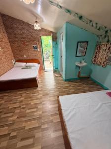 a room with two beds and a sink in it at Cebu - Victoria's Guest House in Badian
