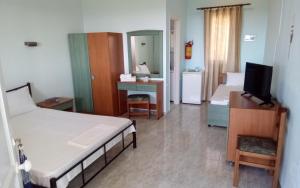 a hotel room with two beds and a television at Panorama Rooms in Kyllini