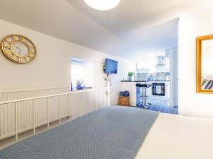 a bedroom with a clock on the wall and a kitchen at Lake View-Uk34414 in Cheddar