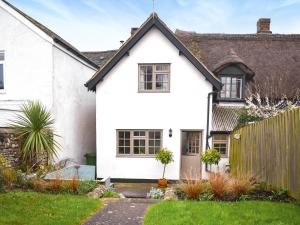 a white house with a black roof at Little Hog Cottage in Seaton