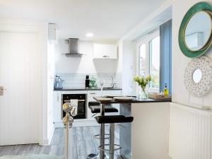 a white kitchen with a counter and a mirror at Meadow View-Uk34416 in Cheddar