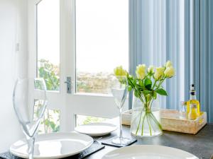 a dining table with white plates and flowers in a vase at Meadow View-Uk34416 in Cheddar