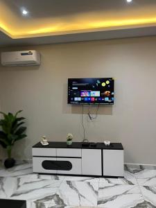 a living room with a tv on a wall at Modern 1bedroom apartment in Douala