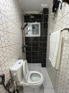 a small bathroom with a toilet and a window at Modern 1bedroom apartment in Douala +12 photos