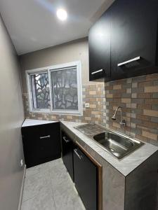 a small kitchen with a sink and a window at Modern 1bedroom apartment in Douala