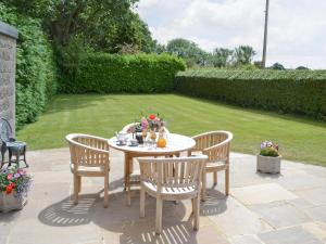 a table and chairs on a patio in a garden at Poplar Bungalow in Lyng