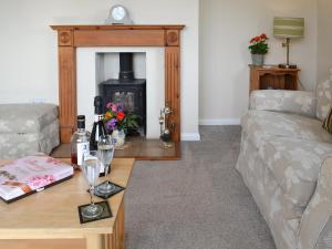 a living room with a couch and a fireplace at Poplar Bungalow in Lyng
