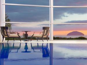 two chairs and a table next to a swimming pool at Royal Aberdeen - Ukc6917 in Turnberry
