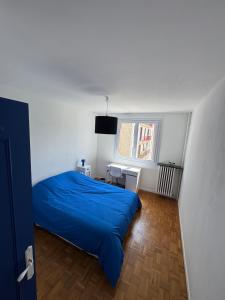 a bedroom with a blue bed and a window at Grand appartement dans une résidence à caen in Caen