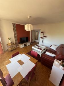 a living room with a table and a couch at Grand appartement dans une résidence à caen in Caen
