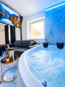 a large tub in a living room with a couch at Luxor - Private Jacuzzi Boulevard Suites in Sibiu
