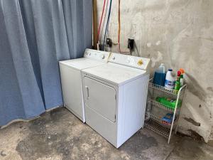 a white washing machine sitting next to a wall at Jefferson Carriage House Hideaway in Huntington +13 photos