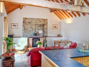 a living room with a couch and a fireplace at Y Dderwen At Brynglas Farm in Llanfair Caereinion +4 photos