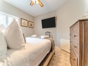 a bedroom with a bed with a dresser and a tv at Royal Dornoch - Ukc6918 in Turnberry
