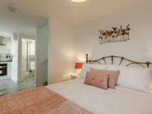 a bedroom with a large white bed with pink pillows at Orchard View-Uk34417 in Cheddar