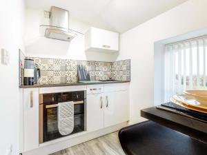 a kitchen with white cabinets and a stove at Tor View-Uk34415 in Cheddar