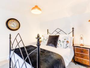 a bedroom with a bed and a clock on the wall at Tor View-Uk34415 in Cheddar