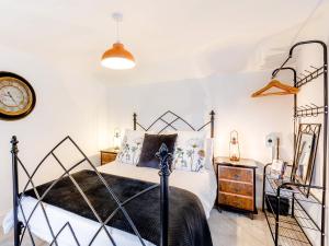 a bedroom with a bed and a clock on the wall at Tor View-Uk34415 in Cheddar +8 photos
