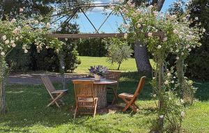 a table and chairs sitting under a tree in a yard at Lovely Home In Tarquinia in Tarquinia