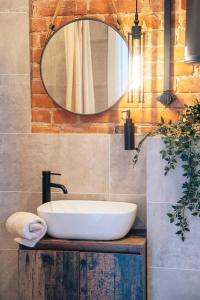 a bathroom with a white sink and a mirror at Old Post Loft Apartments in Spremberg