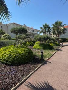a park with bushes and trees and a building at wonderful sea view in Antibes