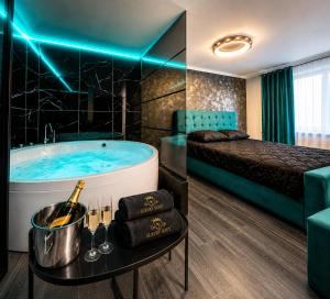 a hotel room with a tub and a bed at Luxor - Private Jacuzzi Boulevard Suites in Sibiu