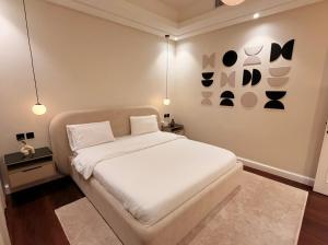 a bedroom with a white bed and some lights at Luxury apartment jeddah in alrawdah 6 Near the airport in Jeddah