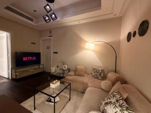 a living room with a couch and a tv at Luxury apartment jeddah in alrawdah 6 Near the airport in Jeddah