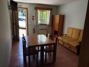 a dining room with a table and a couch at Gerês maravilha in Geres +16 photos