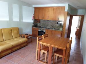 a living room with a couch and a table and a kitchen at Gerês maravilha in Geres